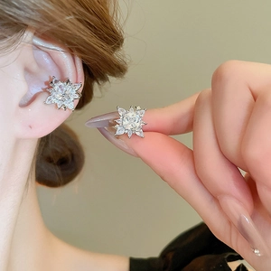 Elegant silver snowflake ear cuffs with sparkling zircons worn by a female model
