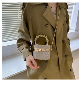 Detailed view of rhinestone bucket bag with golden chain strap on a model
