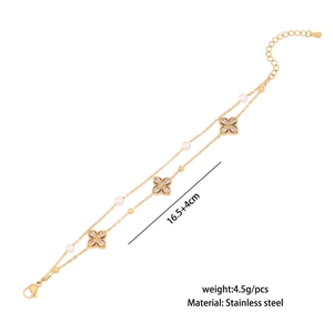 Close-up of double-layer stainless steel gold bracelet with clover charm and white pearl