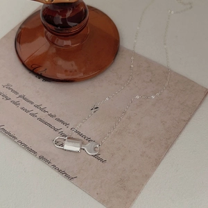 Detailed view of 925 silver padlock and key pendant necklace on a vintage paper background