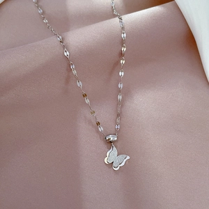 Detail of silver butterfly pendant with water ripple chain on pink silk fabric