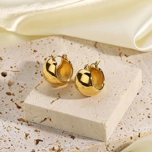 Elegant 18K gold plated chunky stainless steel hoop earrings on stone and silk background