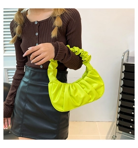Detail of the pleated cloud handbag featuring vibrant neon green PU leather texture