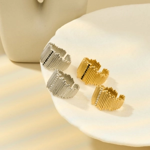 Close-up of gold and silver textured rings with tiny crystals on a white display tray