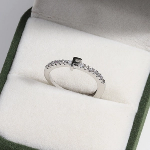 Detail of silver brass ring with letter F and diamonds in a green velvet box