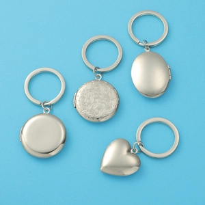 Detailed macro view of four polished stainless steel photo lockets on a blue background