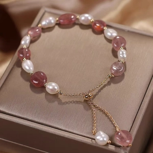 Details des verstellbaren Perlen- und Edelsteinarmbands auf einer goldenen Schmuckbox