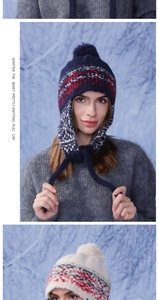 Detail of winter knitted trapper hat with nordic pattern, earflaps and plush pompom
