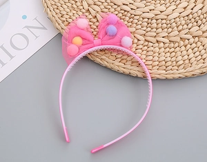 Detail of pink mesh headband for girls with colorful decorative balls and plastic frame