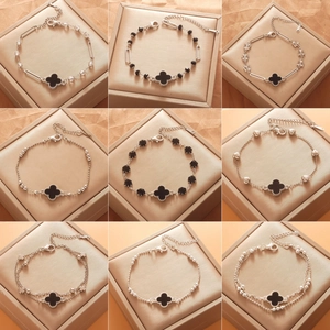 Detailed grid of nine clover charms in silver and black metal finishes on jewelry boxes