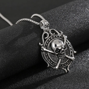Macro shot of silver punk skull and crossbones pendant on textured black surface