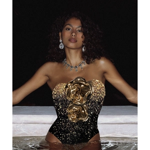 Detail of one-shoulder swimsuit with gold sequins and 3D metallic rose flowers