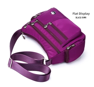 Detail view of purple nylon crossbody bag with multiple zipper layers and adjustable strap