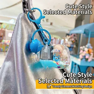 Porte-clés ours bleu avec sable scintillant suspendu sur un sac en cuir argenté chic