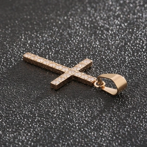 Gros plan détaillé du pendentif croix en acier titane doré incrusté de diamants étincelants