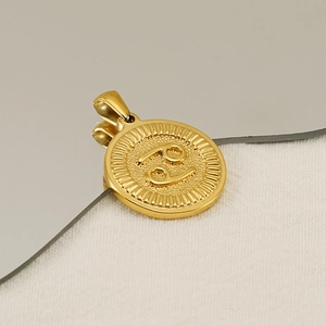 Macro shot of 18K gold plated Cancer zodiac pendant with radial texture on edges