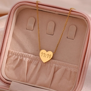 Detailed close-up of a heart pendant necklace with 11:11 engraving in a pink jewelry box