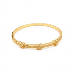18k gold plated X-shaped bangle with cubic zirconia accents on a white background