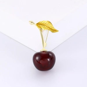 Broche cerise exquise avec des fruits rouge foncé et feuilles dorées sur fond blanc