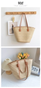 Detail of hand-woven straw tote bag with beige and khaki stripes and fringed edges