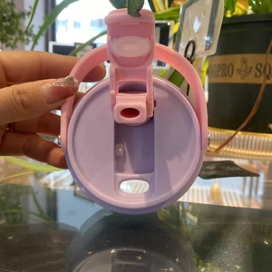 Detail of pink and purple 30oz tumbler lid with portable handle and flip straw switch