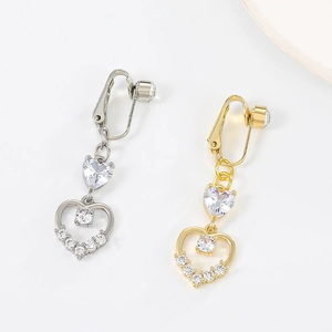 Detailed view of gold and silver clip-on heart drop earrings with shimmering zircon stones