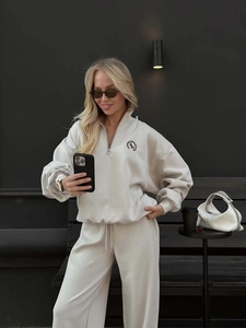 Close-up of cream sweatshirt featuring The Royal Members Club logo and half-zip detail