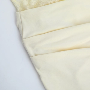 Vue détaillée de la dentelle jaune clair et du tissu plissé sur une robe d'été
