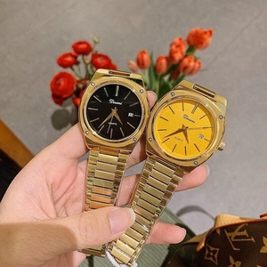 Detail showing gold steel watches with black and yellow square dials and date display