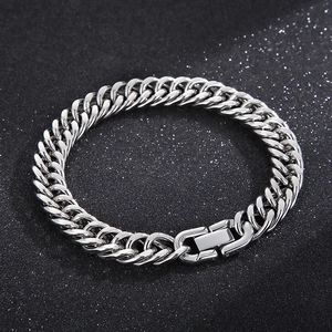 Polished silver cuban link punk bracelet for men on a sparkling black textured background