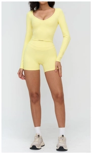 Gros plan sur le haut de yoga jaune à manches longues et le short de fitness sur modèle