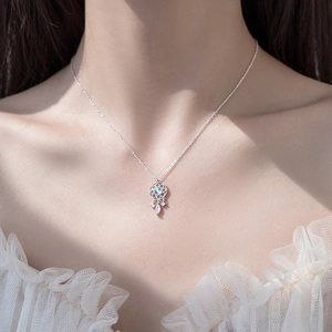 Detail of dreamcatcher necklace with blue gemstone on model with lace collar
