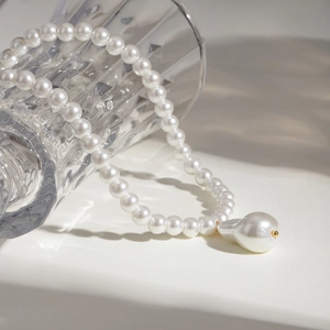 Collana di perle barocche con grande ciondolo oro in un elegante stile retrò francese