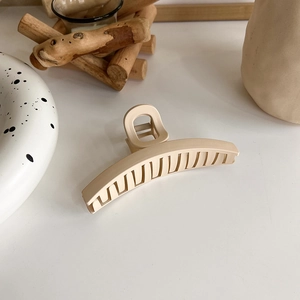 Detailed view of cream beige matte hair claw clip on minimalist Nordic background