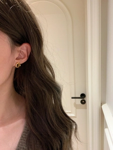 Close-up of elegant 18k gold plated tiger eye stud earrings worn on model ear