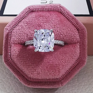 Elegant silver ring with cushion-cut gemstone in a pink velvet box for engagement