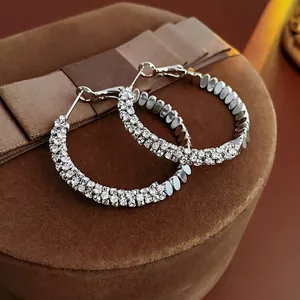 Detail view of silver round earrings with multiple rows of micro-pave zircons
