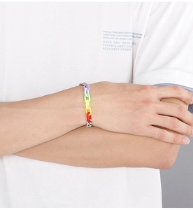 Detail of colorful rainbow acrylic links and silver chain bracelet on model's wrist