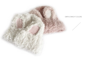 Detailed plush texture of white and pink knitted beanies with sweet bunny ears