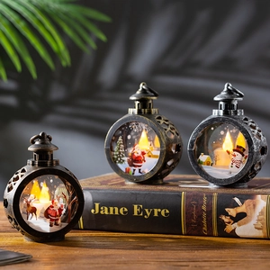 Vintage Christmas LED lanterns with Santa and Elk motifs on retro book display