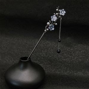 Épingle à cheveux fleurie avec glands en perles et fleurs bleues sur vase noir