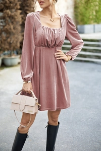 Detail van roze fluwelen jurk met een vierkante halslijn en elegante pofmouwen