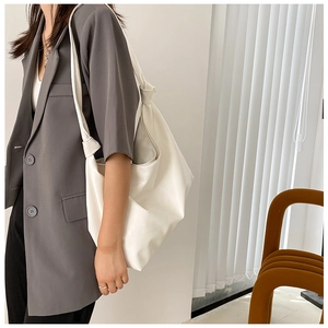 Close-up of a white large capacity tote bag showing soft leather texture and natural drape