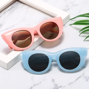 Retro-Katzenaugen-Sonnenbrille mit dicken rosa und blauen Rahmen auf weißem Marmor