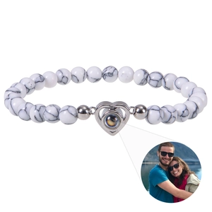 Detail of custom heart projection bracelet with white marble beads and photo pendant