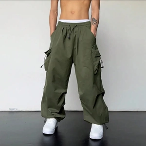 Détail du pantalon cargo vert olive avec taille à cordon et grandes poches latérales