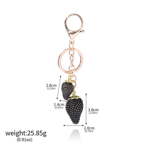 Detailed view of two textured black strawberry charms with rose gold hardware and size specs