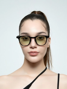 Close-up of circular small frame sunglasses with yellow lenses on a male model