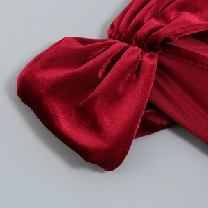 Détail macro du tissu en velours rouge foncé avec nœud élégant et texture plissée