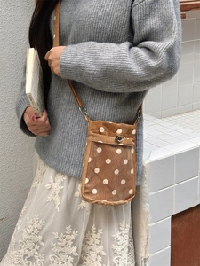 Detailansicht der braunen Cord-Handytasche mit Polka-Dots und transparentem Fach